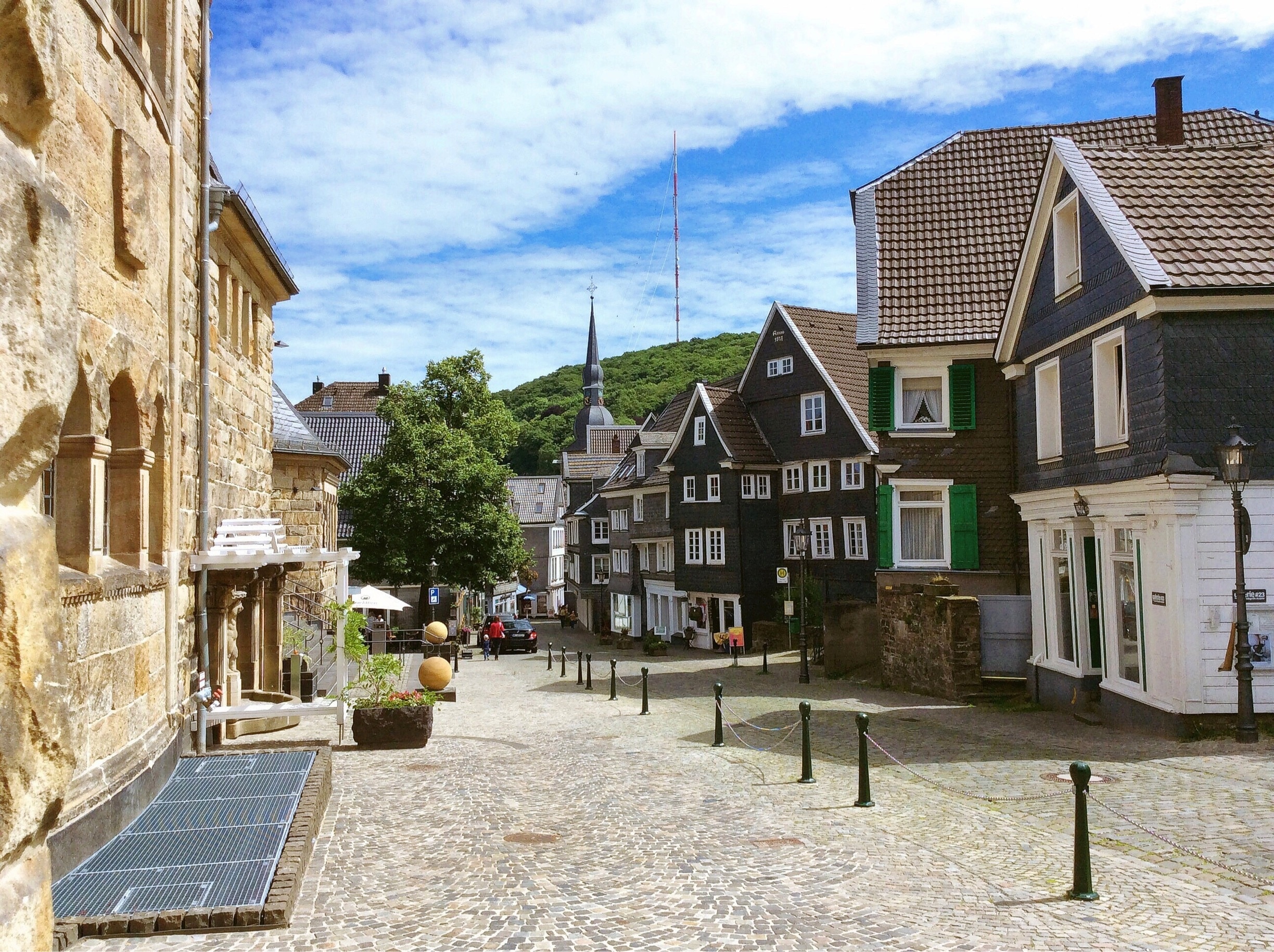 Historischer Ortskern von Velbert mit Fachwerk- und Schieferhäusern an einem gepflasterten Platz, daneben Text zur Erstellung eines individuellen Sanierungsfahrplans (iSFP).